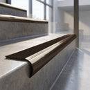 Antique Bronze finish - solid brass raked back stair nosing with CarbiGrip - Hazelnut insert fitted on concrete steps