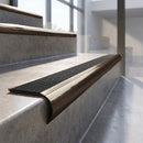 Antique Bronze finish - solid brass raked back stair nosing with CarbiGrip - Obsidian insert fitted on concrete steps