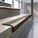 Antique Bronze finish - solid brass raked back stair nosing with CarbiGrip - Pebble insert fitted on concrete steps