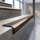 Antique Bronze finish - solid brass raked back stair nosing with CarbiGrip - Speckled Graphite insert fitted on concrete steps