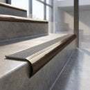 Antique Bronze finish - solid brass raked back stair nosing with CarbiGrip - Speckled Pebble insert fitted on concrete steps