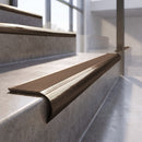 Antique Bronze finish - solid brass raked back stair nosing with Ridged PVC - Canary insert fitted on concrete steps