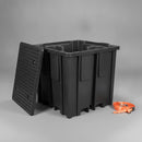 Empty black recycled polyethylene single IBC spill pallet on a grey studio background, with its removable perforated grid deck leaning against the ribbed sump body and fork pockets visible at the base