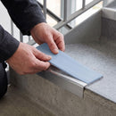 Replacement Aura PVC insert strip being pressed into the channel of an aluminium stair nosing