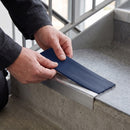 Replacement Dark Blue PVC insert strip being pressed into the channel of an aluminium stair nosing