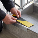 Replacement Hazard PVC insert strip being pressed into the channel of an aluminium stair nosing