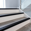 Black anodised aluminium ribbed stair nosing edge trim 40x20mm fitted on grey vinyl steps in an apartment communal stairwell
