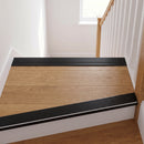 Black anodised aluminium ribbed stair nosing edge trim 40x20mm fitted to oak stair treads at a first-floor landing
