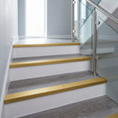 Gold anodised aluminium ribbed stair nosing edge trim 40x20mm fitted on grey vinyl steps in an apartment communal stairwell