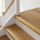 Gold anodised aluminium ribbed stair nosing edge trim 40x20mm fitted to oak stair treads at a first-floor landing