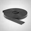 Ten metre roll out cable ramp coiled flat with one end unwound, showing the ribbed black rubber top surface and the round cable channel at the cut end, on a plain studio background