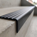 Close-up of the four moulded anti-slip flutes and rounded nose on a 40x40mm flexible PVC stair nosing fitted to a concrete step