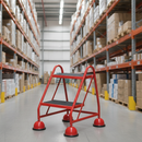 Red mobile safety steps with twin handrail in a warehouse aisle