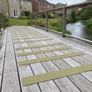 Sage green 90mm fine grit GRP anti-slip decking strips on a riverside garden deck