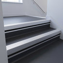Satin Aluminium insert in a 66x55mm square front aluminium stair nosing with 13mm black riser highlight, fitted to interior steps