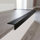 Black self adhesive stair nosing fitted to a grey laminate step edge in a home hallway
