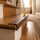 Brown self adhesive stair nosing fitted to an oak staircase step in a traditional home