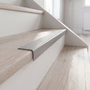 Light grey self adhesive stair nosing fitted to a pale laminate step in a modern home
