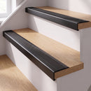 Black anodised self-adhesive 46x30mm stair nosing with black anti-slip rubber insert fitted to oak timber stairs in a home