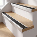 Silver anodised self-adhesive 46x30mm stair nosing with black anti-slip rubber insert fitted to oak timber stairs in a home