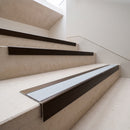 Dark bronze aluminium stair nosing with everest insert on pale limestone treads in a museum gallery stair