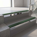 Square-edge aluminium stair nosing with a deep 56mm riser face in Bright Polished, fitted along two vinyl-covered concrete steps in an office stairwell, with a Dark Green anti-slip PVC insert running the full width of each step