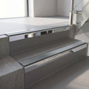 Square-edge aluminium stair nosing with a deep 56mm riser face in Bright Polished, fitted along two vinyl-covered concrete steps in an office stairwell, with a Mid Grey anti-slip PVC insert running the full width of each step