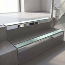 Square-edge aluminium stair nosing with a deep 56mm riser face in Bright Polished, fitted along two vinyl-covered concrete steps in an office stairwell, with a Sage Green anti-slip PVC insert running the full width of each step