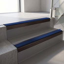 Square-edge aluminium stair nosing with a deep 56mm riser face in Dark Bronze, fitted along two vinyl-covered concrete steps in an office stairwell, with a Dark Blue anti-slip PVC insert running the full width of each step