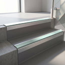 Square-edge aluminium stair nosing with a deep 56mm riser face in Mill Finish, fitted along two vinyl-covered concrete steps in an office stairwell, with a Sage Green anti-slip PVC insert running the full width of each step
