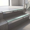 Square-edge aluminium stair nosing with a deep 56mm riser face in Mirroflect Silver, fitted along two vinyl-covered concrete steps in an office stairwell, with a Sage Green anti-slip PVC insert running the full width of each step