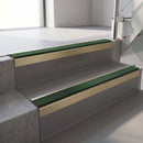 Square-edge aluminium stair nosing with a deep 56mm riser face in Satin Gold, fitted along two vinyl-covered concrete steps in an office stairwell, with a Dark Green anti-slip PVC insert running the full width of each step