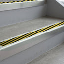 Bright Polished deep-riser square-edge aluminium stair nosing fitted along two bare concrete steps, 62mm tread plate and 56mm front face, with a Hazard anti-slip insert running the full width of each step
