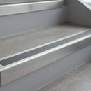Bright Polished deep-riser square-edge aluminium stair nosing fitted along two bare concrete steps, 62mm tread plate and 56mm front face, with a Mid Grey anti-slip insert running the full width of each step