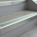 Bright Polished deep-riser square-edge aluminium stair nosing fitted along two bare concrete steps, 62mm tread plate and 56mm front face, with a Sage Green anti-slip insert running the full width of each step