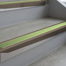 Dark Bronze deep-riser square-edge aluminium stair nosing fitted along two bare concrete steps, 62mm tread plate and 56mm front face, with a Apple Green anti-slip insert running the full width of each step