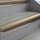 Dark Bronze deep-riser square-edge aluminium stair nosing fitted along two bare concrete steps, 62mm tread plate and 56mm front face, with a Beige anti-slip insert running the full width of each step
