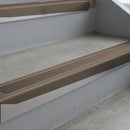 Dark Bronze deep-riser square-edge aluminium stair nosing fitted along two bare concrete steps, 62mm tread plate and 56mm front face, with a Brown anti-slip insert running the full width of each step