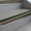 Dark Bronze deep-riser square-edge aluminium stair nosing fitted along two bare concrete steps, 62mm tread plate and 56mm front face, with a Dark Green anti-slip insert running the full width of each step