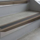 Dark Bronze deep-riser square-edge aluminium stair nosing fitted along two bare concrete steps, 62mm tread plate and 56mm front face, with a Dark Grey anti-slip insert running the full width of each step