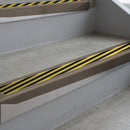 Dark Bronze deep-riser square-edge aluminium stair nosing fitted along two bare concrete steps, 62mm tread plate and 56mm front face, with a Hazard anti-slip insert running the full width of each step