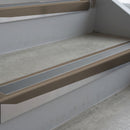 Dark Bronze deep-riser square-edge aluminium stair nosing fitted along two bare concrete steps, 62mm tread plate and 56mm front face, with a Mid Grey anti-slip insert running the full width of each step