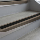 Dark Bronze deep-riser square-edge aluminium stair nosing fitted along two bare concrete steps, 62mm tread plate and 56mm front face, with a Premium Black anti-slip insert running the full width of each step