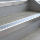 Mill Finish deep-riser square-edge aluminium stair nosing fitted along two bare concrete steps, 62mm tread plate and 56mm front face, with a Aura anti-slip insert running the full width of each step