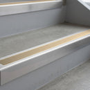 Mill Finish deep-riser square-edge aluminium stair nosing fitted along two bare concrete steps, 62mm tread plate and 56mm front face, with a Beige anti-slip insert running the full width of each step