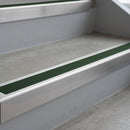 Mill Finish deep-riser square-edge aluminium stair nosing fitted along two bare concrete steps, 62mm tread plate and 56mm front face, with a Dark Green anti-slip insert running the full width of each step