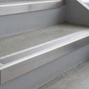 Mill Finish deep-riser square-edge aluminium stair nosing fitted along two bare concrete steps, 62mm tread plate and 56mm front face, with a Polar Grey anti-slip insert running the full width of each step