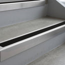 Mill Finish deep-riser square-edge aluminium stair nosing fitted along two bare concrete steps, 62mm tread plate and 56mm front face, with a Premium Black anti-slip insert running the full width of each step