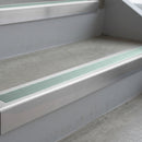 Mill Finish deep-riser square-edge aluminium stair nosing fitted along two bare concrete steps, 62mm tread plate and 56mm front face, with a Sage Green anti-slip insert running the full width of each step