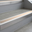 Mill Finish deep-riser square-edge aluminium stair nosing fitted along two bare concrete steps, 62mm tread plate and 56mm front face, with a Sahara anti-slip insert running the full width of each step